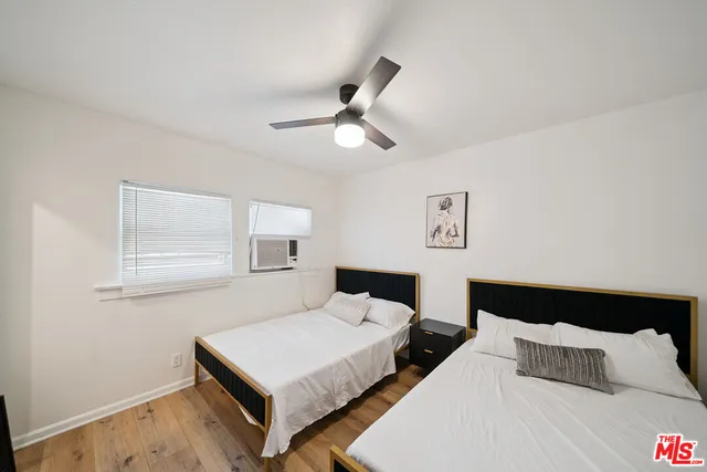 a bedroom with a bed and a chandelier fan