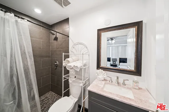 a bathroom with a sink vanity mirror and toilet