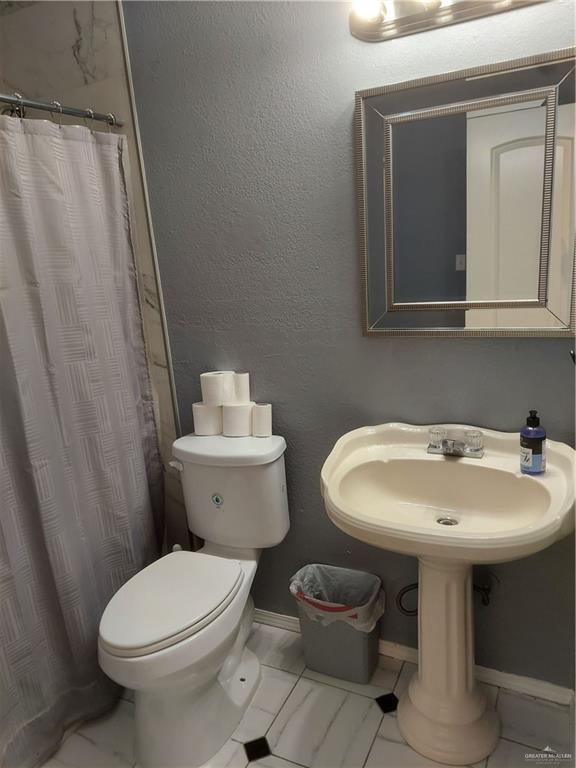 115 Breyfogle Road Palmview, TX 78572 - Photo 11 of 31 a bathroom with a toilet sink and mirror