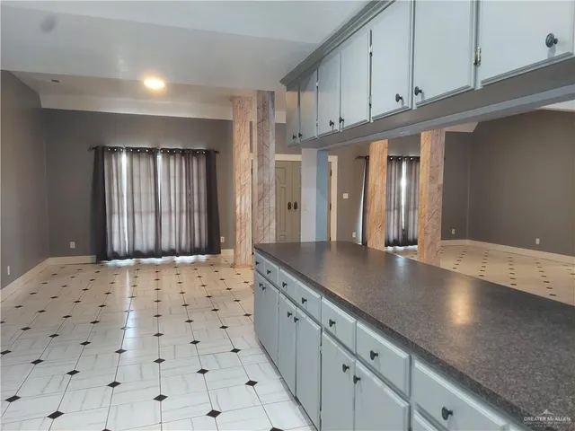 a kitchen with granite countertop a sink a stove and cabinets