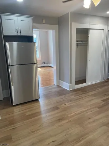 a view of empty room with wooden floor