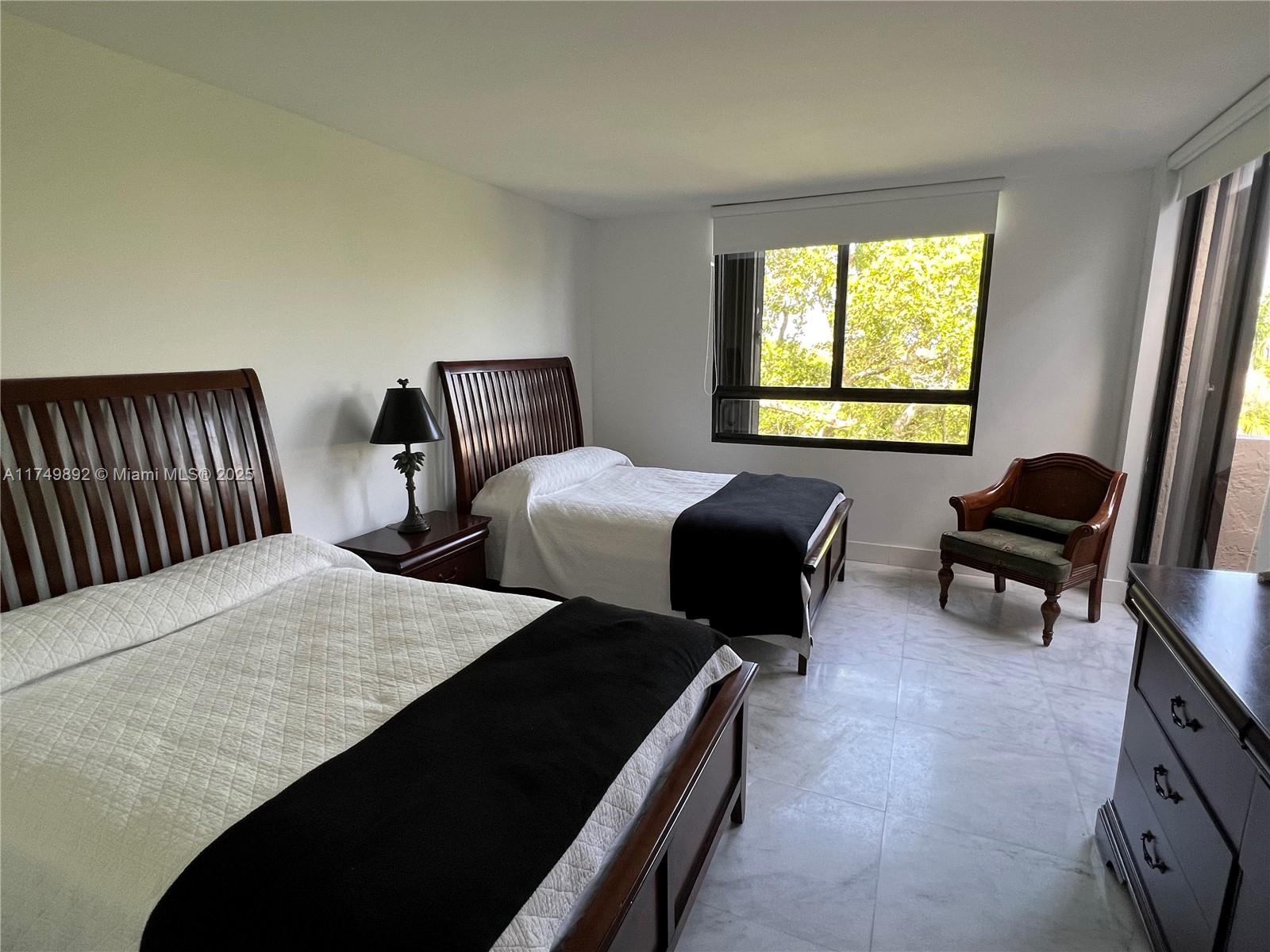 101 Crandon Boulevard, Unit 474 Key Biscayne, FL 33149 - Photo 6 of 9 a bedroom with two beds and a dresser next to a window