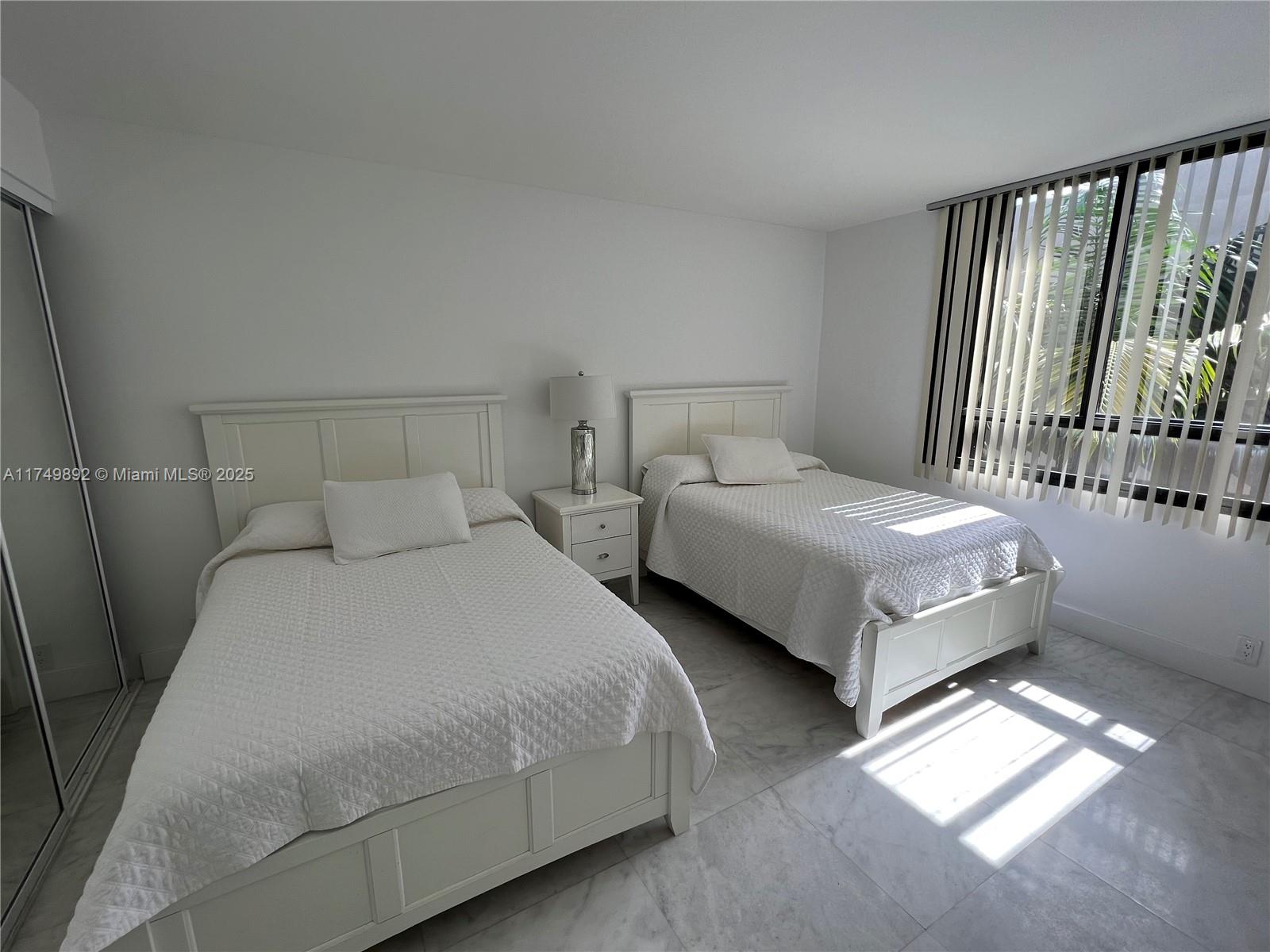 101 Crandon Boulevard, Unit 474 Key Biscayne, FL 33149 - Photo 8 of 9 a bedroom with two beds and a window