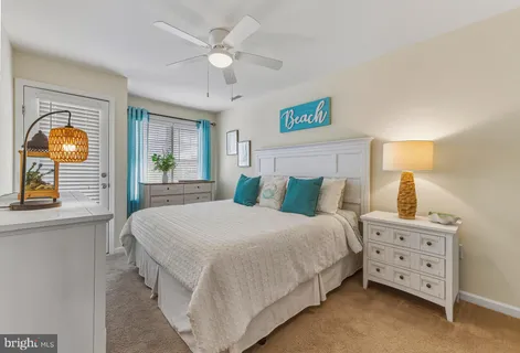 a bedroom with a bed a dresser and painting on the wall