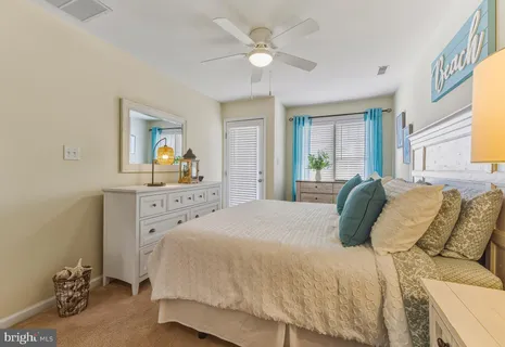 a spacious bedroom with a bed a dresser and next to a window