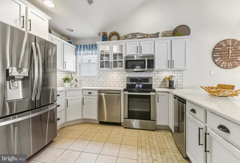 a kitchen with stainless steel appliances a stove a sink and a refrigerator