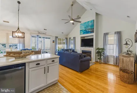 a kitchen with a stove a sink a center island a dining table and chairs