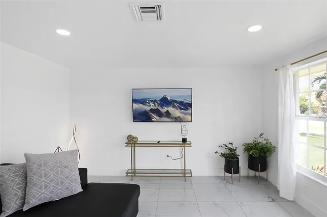 a living room with furniture and potted plants
