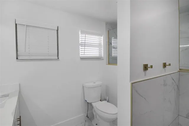 a living room with furniture a large window and wooden floor