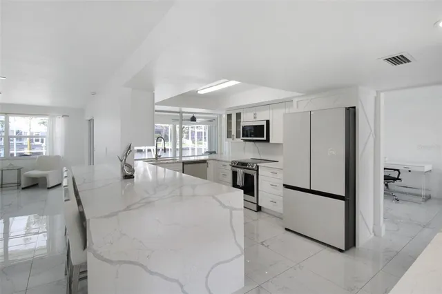 a living room with furniture and a dining table with a chandelier
