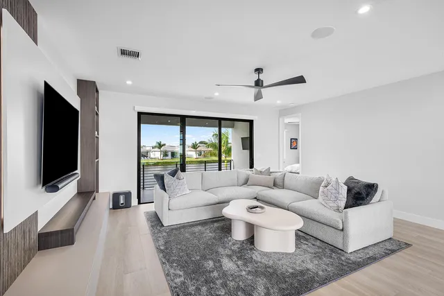 a view of a swimming pool with lounge chair and palm trees