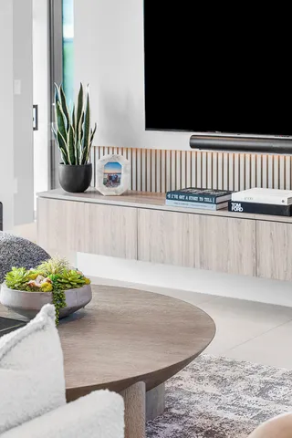 a kitchen with stainless steel appliances a stove a sink a microwave a dining table and chairs with the view of living room