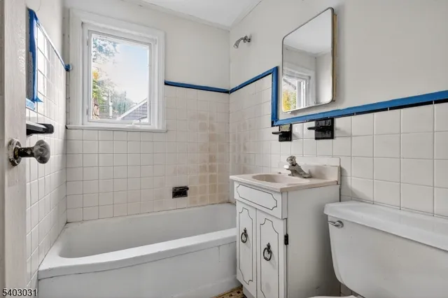 a bathroom with a granite countertop sink a toilet and shower