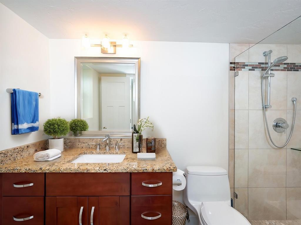 101 South Gulfstream Avenue, Unit 10E Sarasota, FL 34236 - Photo 10 of 54 a bathroom with a granite countertop sink and a mirror