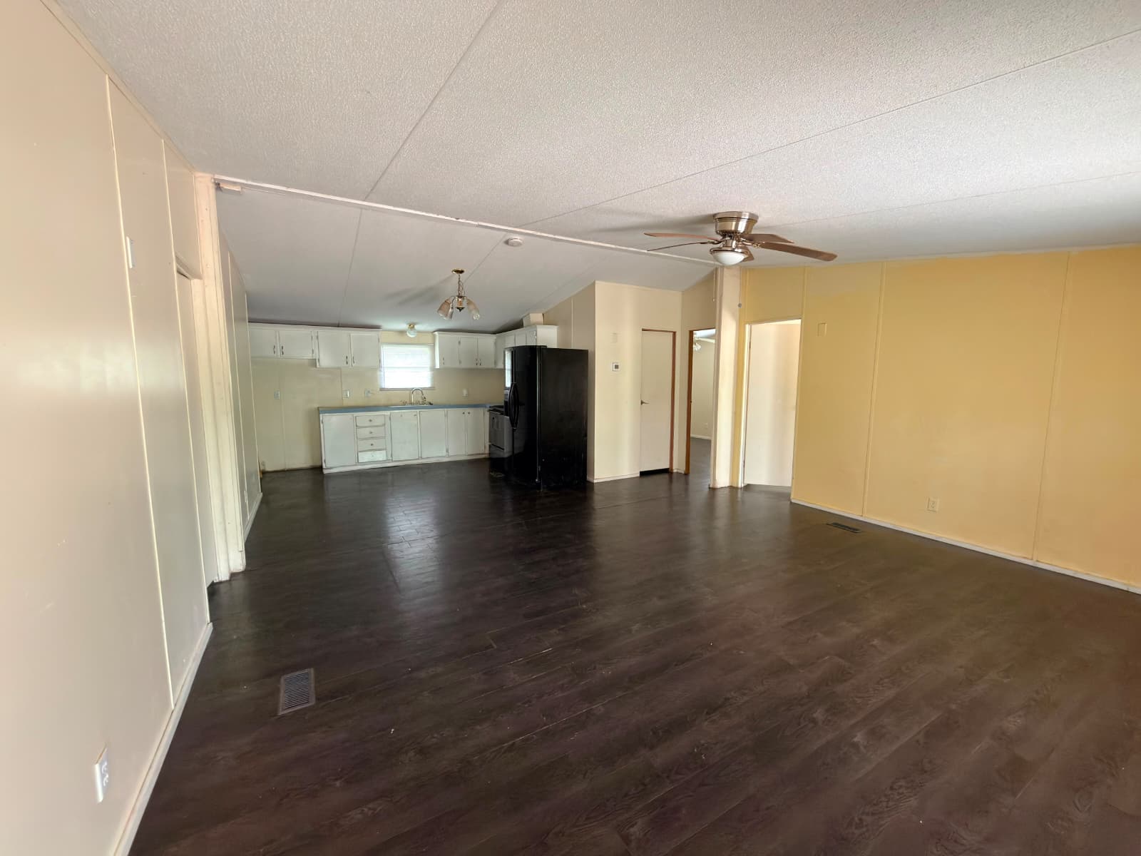 8607 Burleson Manor Road, Unit A Manor, TX 78653 - Photo 13 of 13 An open floor plan connects the well-lit kitchen with dark wood flooring to the spacious living area.