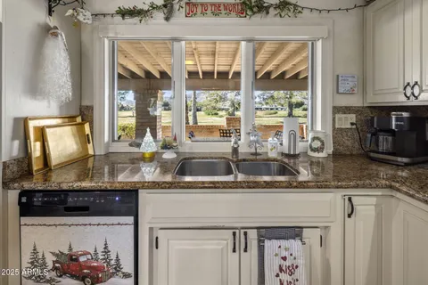 a kitchen with stainless steel appliances kitchen island granite countertop a sink and a stove