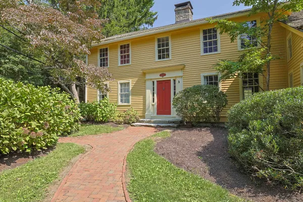a front view of a house with a garden and plants