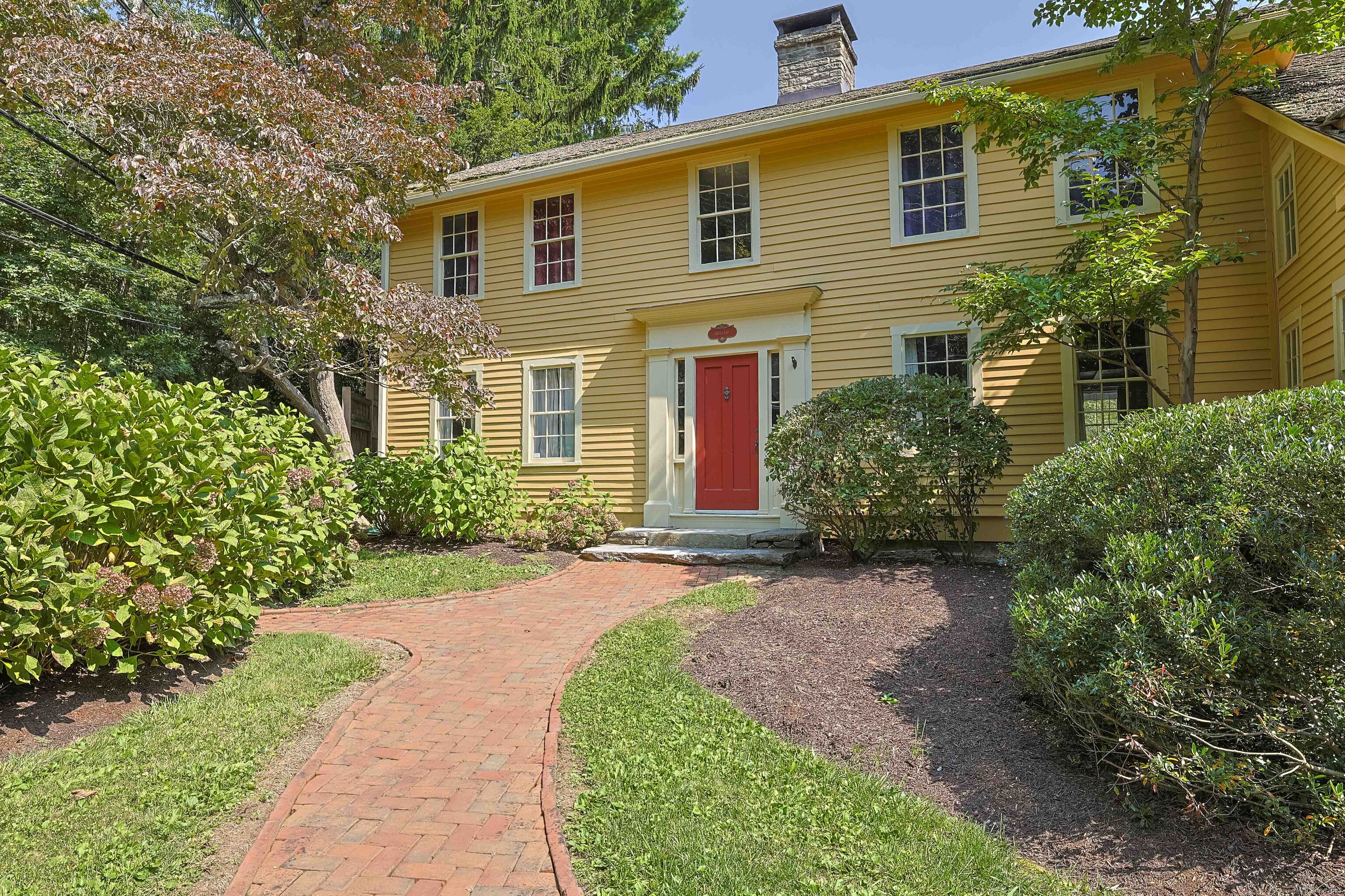 a front view of a house with a garden and plants