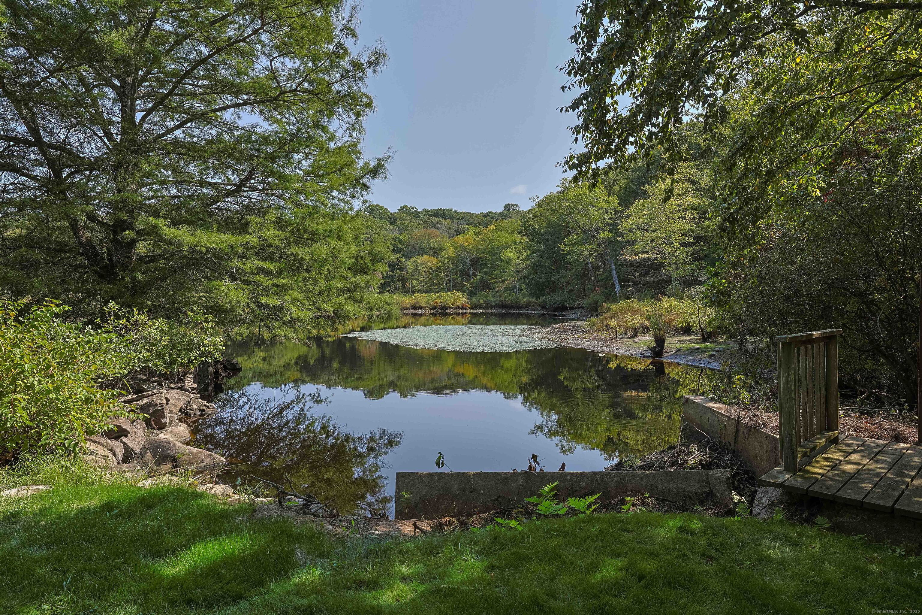 180 Green Hill Road Killingworth, CT 06419 - Photo 35 of 39 a view of a lake with lawn chairs and large trees