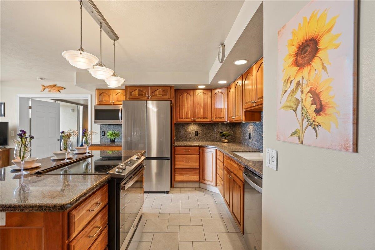 1993 South Kihei Road, Unit 601 Kihei, HI 96753 - Photo 12 of 45 a kitchen with stainless steel appliances granite countertop a sink a stove and a refrigerator
