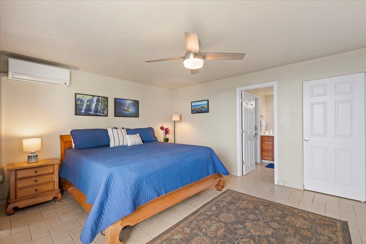 1993 South Kihei Road, Unit 601 Kihei, HI 96753 - Photo 19 of 45 a bedroom with a bed and a chandelier