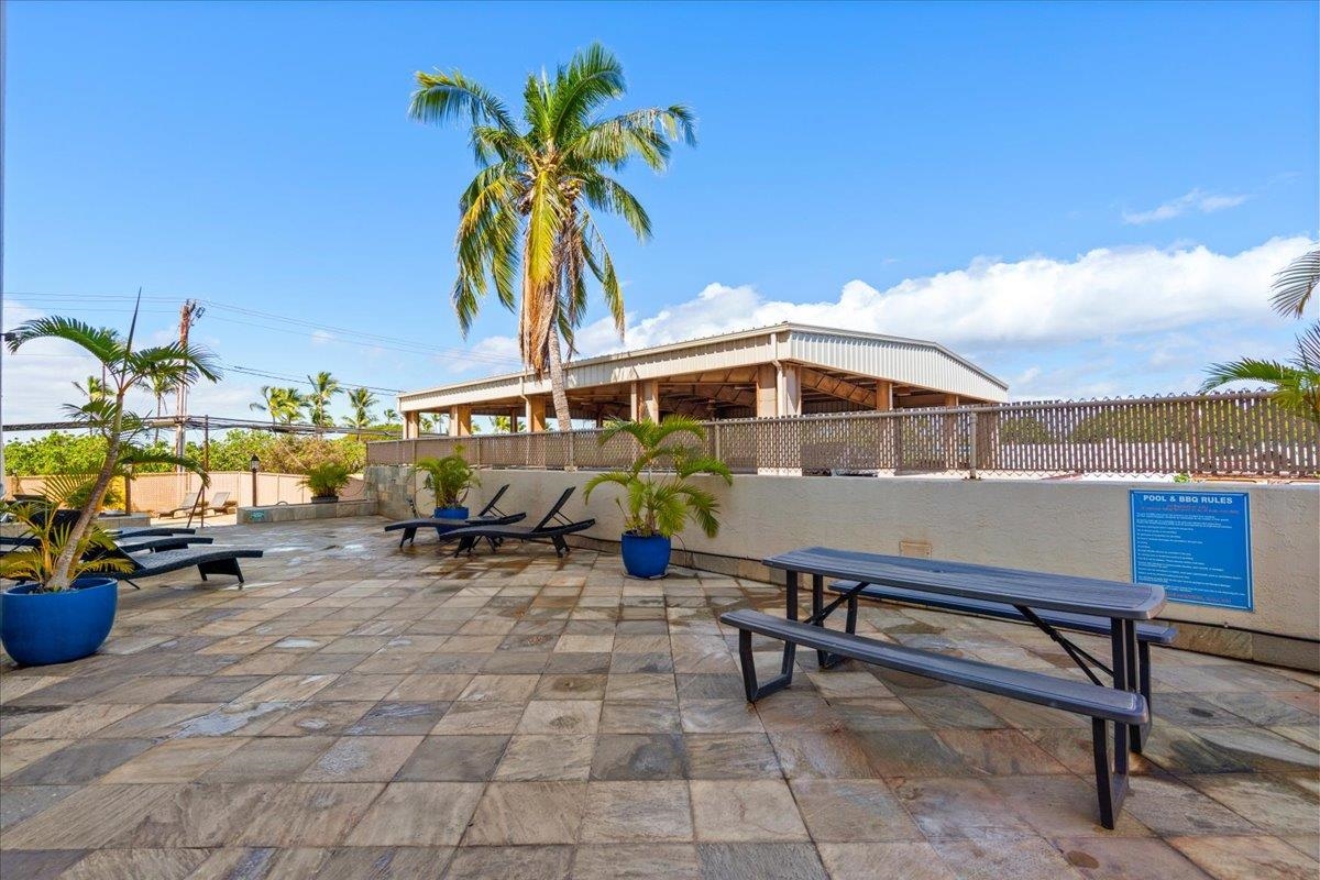 1993 South Kihei Road, Unit 601 Kihei, HI 96753 - Photo 45 of 45 a roof deck with table and chairs under an umbrella with potted plants