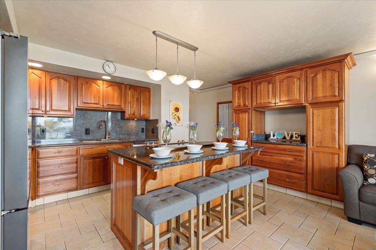 1993 South Kihei Road, Unit 601 Kihei, HI 96753 - Photo 5 of 45 a kitchen with stainless steel appliances granite countertop a stove a sink dishwasher and a refrigerator with wooden cabinets