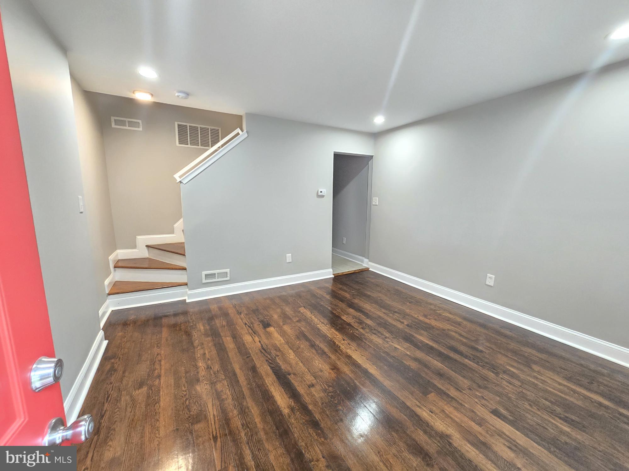 144 Chestnut Street Baltimore, MD 21222 - Photo 2 of 14 an empty room with wooden floor and entrance