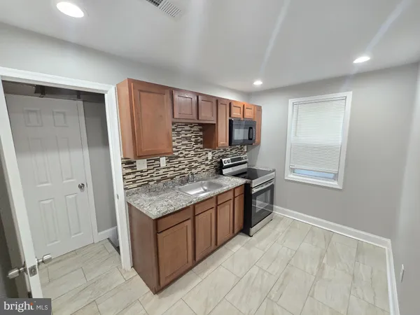 a kitchen with stainless steel appliances granite countertop a stove and a refrigerator