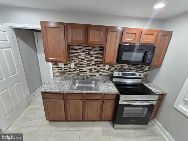 a kitchen with granite countertop a stove and a sink