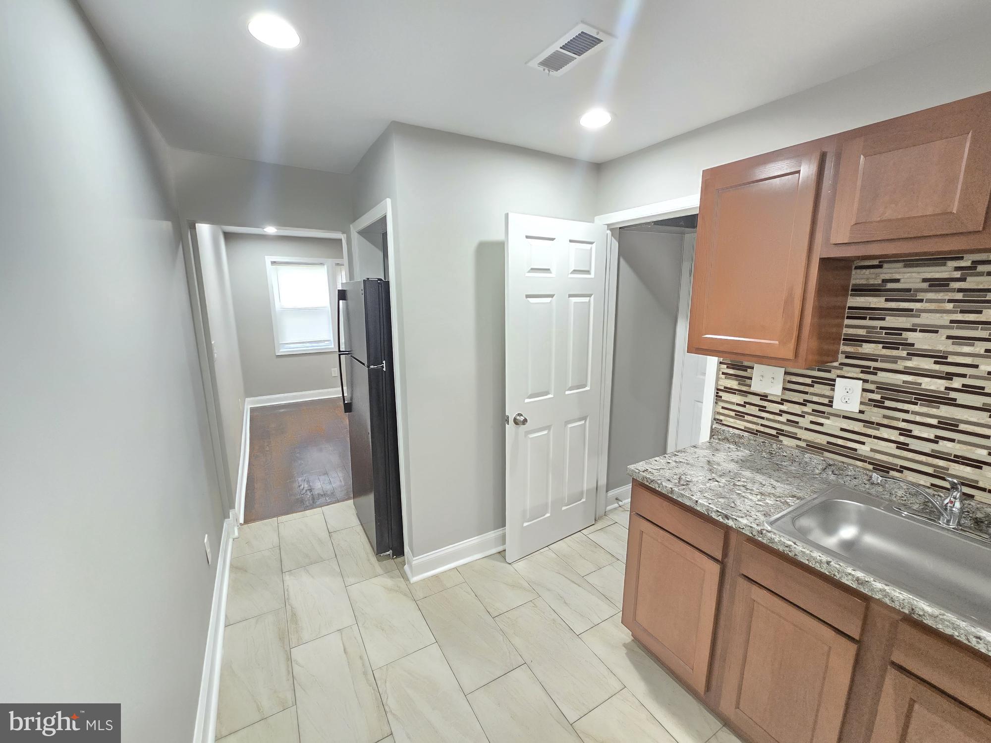 144 Chestnut Street Baltimore, MD 21222 - Photo 6 of 14 a kitchen with stainless steel appliances granite countertop a refrigerator and a sink