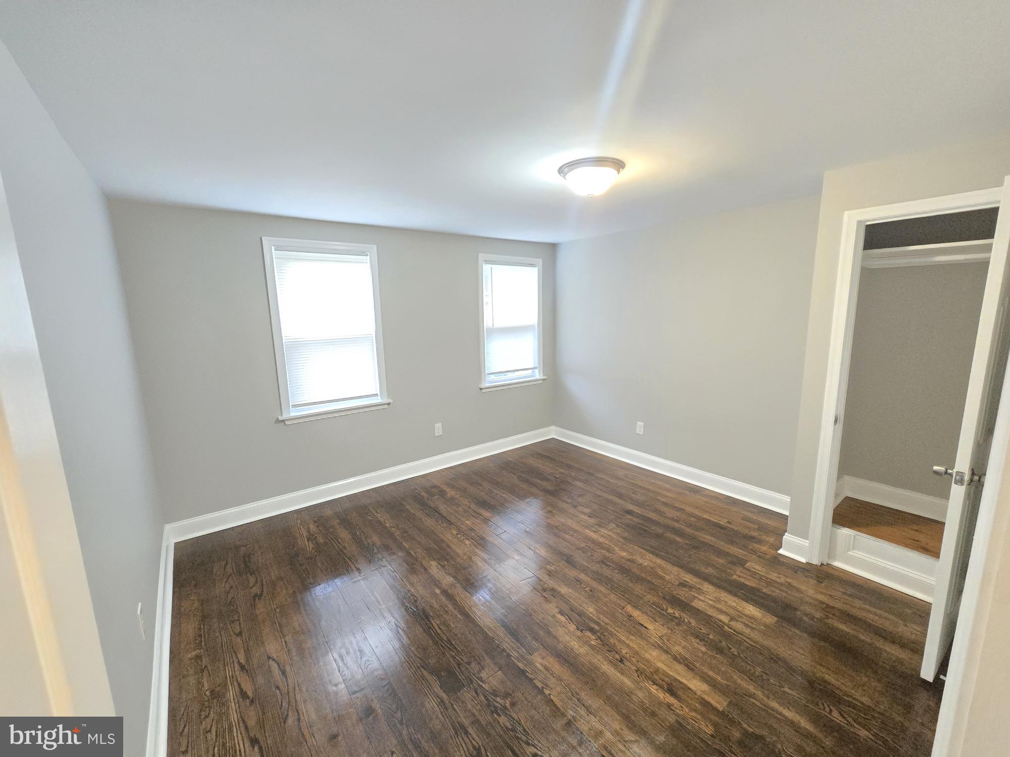 144 Chestnut Street Baltimore, MD 21222 - Photo 7 of 14 an empty room with wooden floor and windows