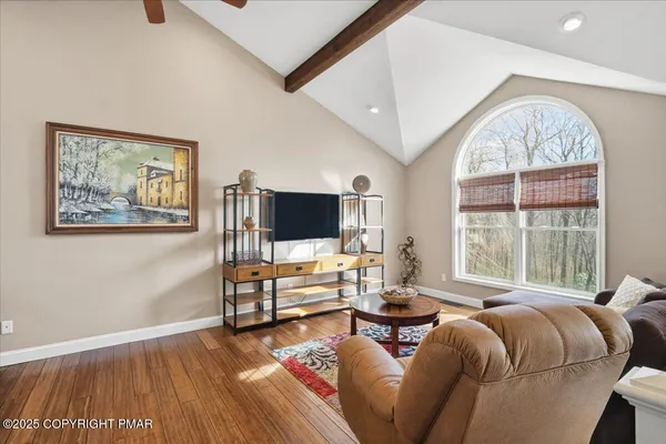 a living room with furniture a flat screen tv and a large window