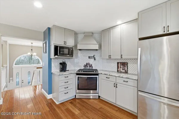 a kitchen with white cabinets and stainless steel appliances