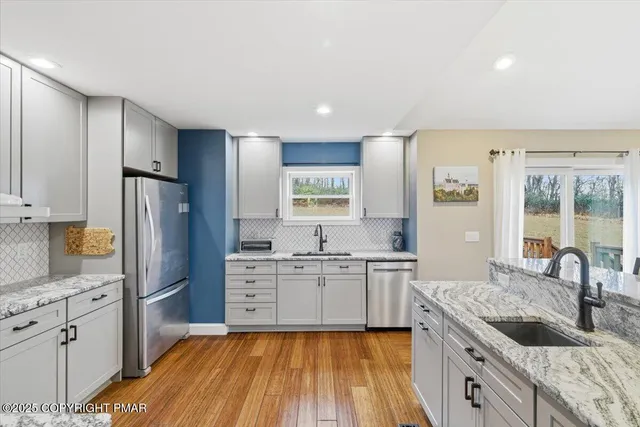 a kitchen with stainless steel appliances granite countertop a sink stove and refrigerator