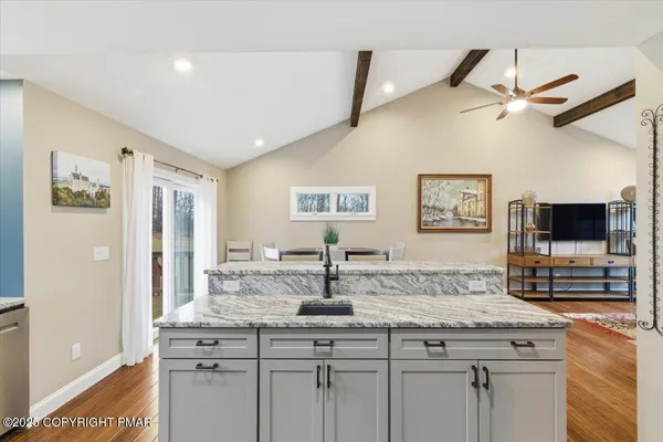 a bathroom with a granite countertop sink a mirror and shower