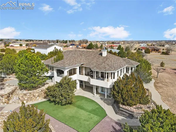 an aerial view of residential houses with outdoor space and trees