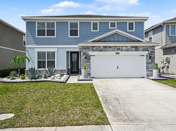 a view of a house with a yard and sitting area