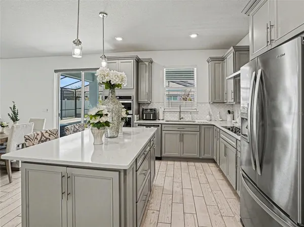 a kitchen with stainless steel appliances granite countertop a sink refrigerator and cabinets
