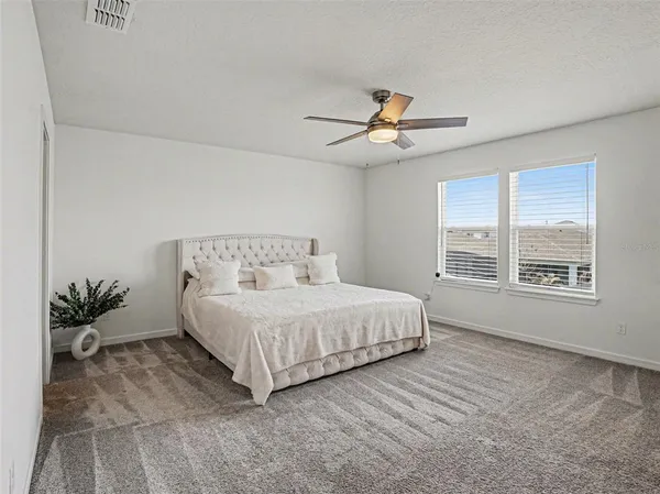 a spacious bedroom with a bed and a chandelier