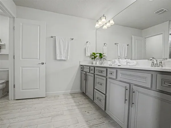 a spacious bathroom with a double vanity sink and a mirror