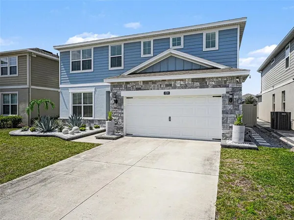 a view of a house with potted plants and a yard