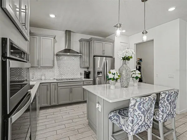 a kitchen with kitchen island granite countertop a sink stove and refrigerator