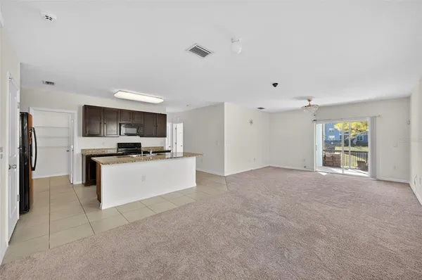 a kitchen with stainless steel appliances kitchen island a refrigerator sink and cabinets