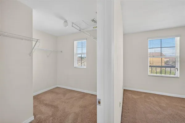 a view of a big room with windows and chandelier fan