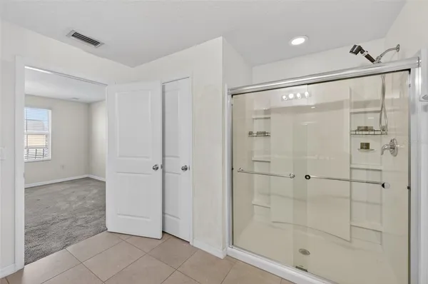 a bathroom with a shower and a glass door