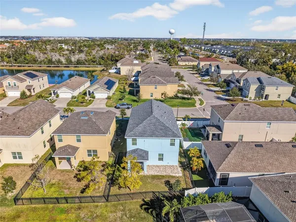 an aerial view of residential houses with outdoor space and ocean view