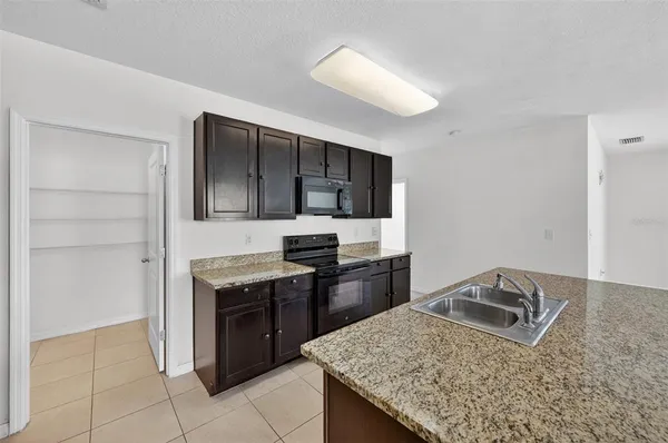a kitchen with stainless steel appliances granite countertop a sink dishwasher stove and oven