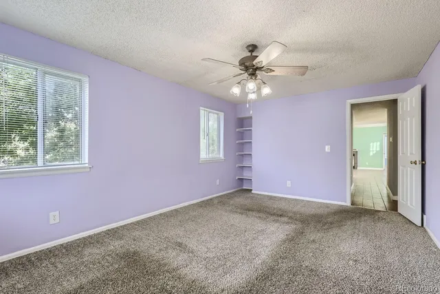 a view of a livingroom with a ceiling fan and window