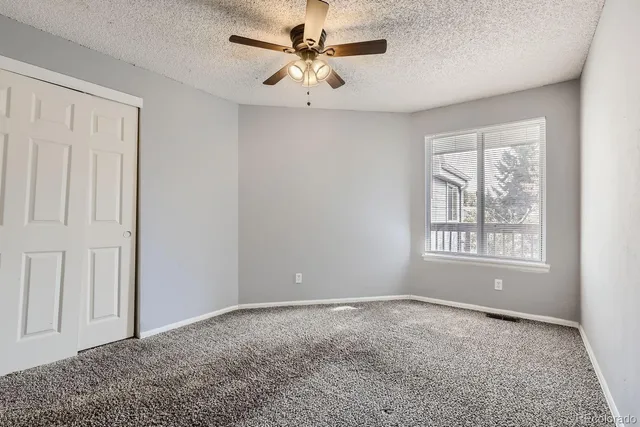a big room with windows and chandelier fan